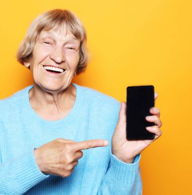 Yeni akıllı telefonlu olgun bir kadının resmi..