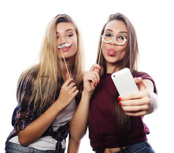 Tehnology, emotion and people concept: happy best girlfriends making selfie on smartphone over white background — Stock Photo, Image