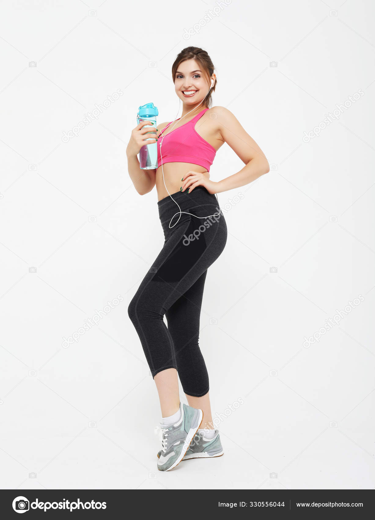 Concepto de deporte, personas y fitness: mujer joven con ropa deportiva  sosteniendo una botella con agua sobre fondo blanco: fotografía de stock ©  kanareva #330556044