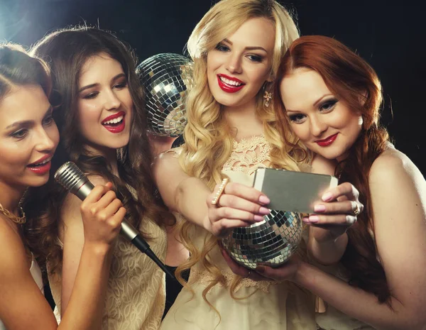 Крупный план группы смеющихся девушек, устраивающих вечеринку, делающих селфи со смартфоном — стоковое фото
