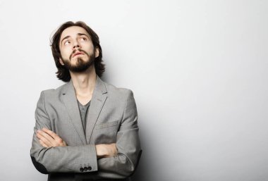 Beyaz arka planda poz veren sakallı genç bir adamın portresi.