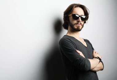 Moda ve insan konsepti: güneş gözlüğü takan genç bir adamın portresi