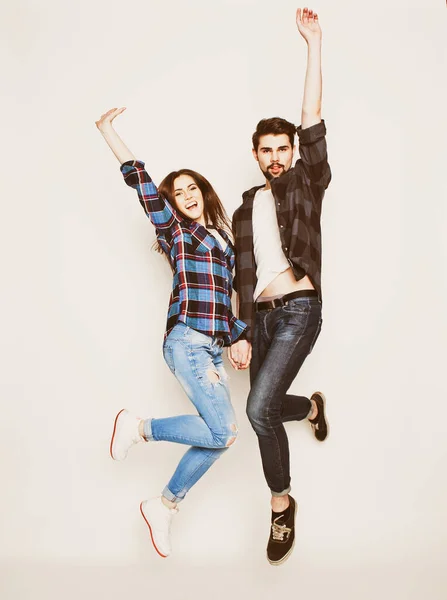 Life style, happiness and people concept: Happy loving couple. Jumping over light grey background. — Stock Photo, Image