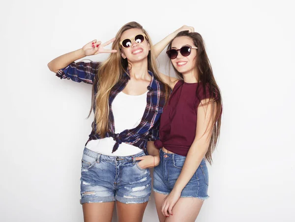 Lifestyle, emotie en people concept: Twee jonge vriendinnen die samen staan en plezier hebben. Hipster stijl. — Stockfoto
