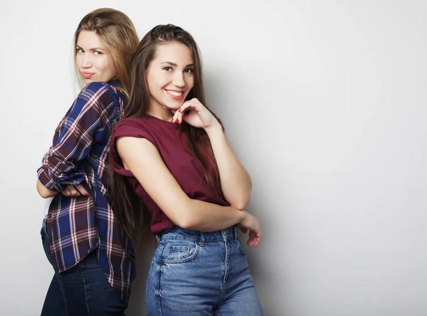 Estilo de vida y el concepto de la gente: Dos amigas jóvenes de pie juntos y divirtiéndose. Estilo Hipster . —  Fotos de Stock