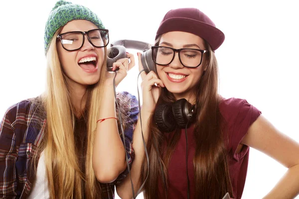 Dvě mladé přítelkyně stojí spolu a poslouchají hudbu a zpěv — Stock fotografie