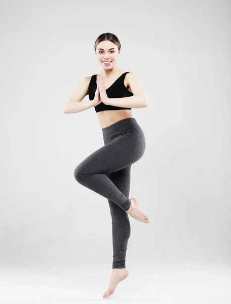 Encantadora joven en ropa deportiva saltando sobre un fondo blanco, concepto de deporte — Foto de Stock