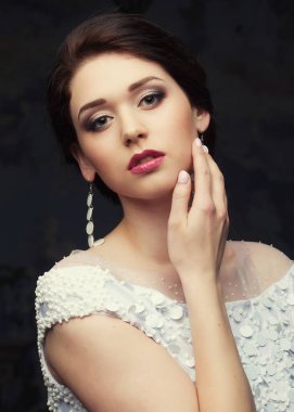 Beyaz elbiseli, şapkalı ve küpeli güzel gelin, güzellik ve gençlik, mutluluk ve masumiyet.