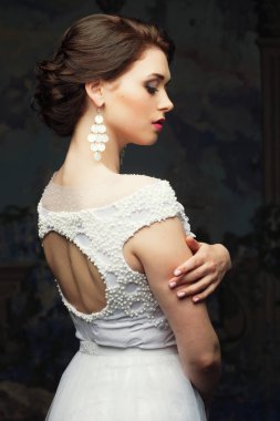 Beyaz elbiseli, şapkalı ve küpeli güzel gelin, güzellik ve gençlik, mutluluk ve masumiyet.