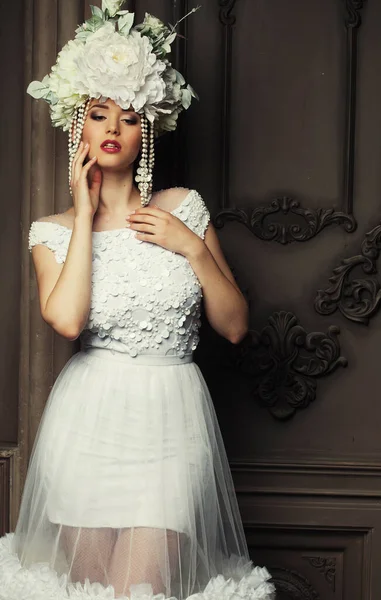 Hermosa novia en un vestido blanco, sombrero y pendientes, belleza y juventud, felicidad e inocencia — Foto de Stock