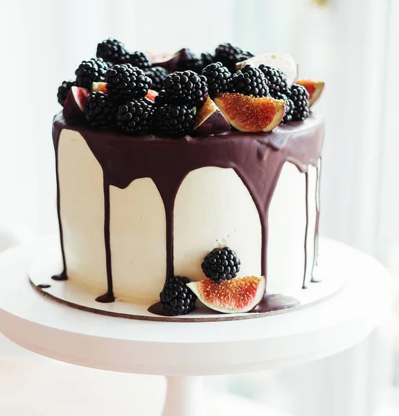 Изысканный торт, пропитанный шоколадом и украшенный ежевикой и инжиром. Сладости. — стоковое фото