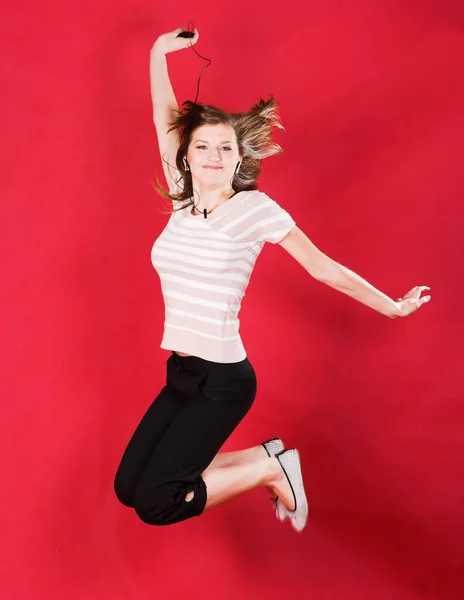 Girl jumping of joy over red — Stock Photo, Image