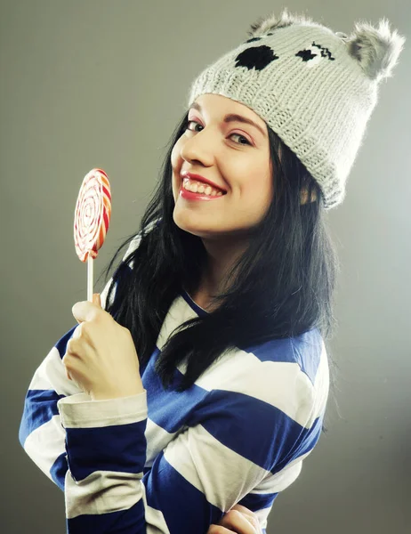 Mujer con sombrero de invierno celebración de piruleta grande — Foto de Stock