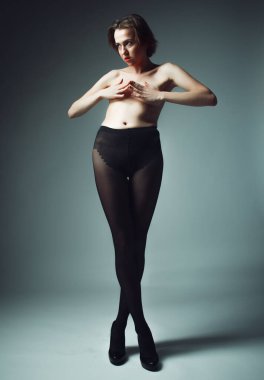 Siyah külotlu çorap giyen kısa sarı saçlı bir manken.