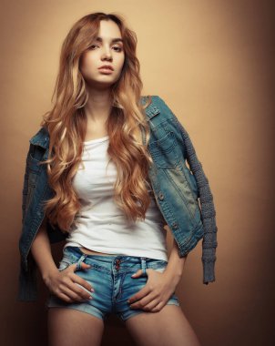 Stüdyoda sarı arka planda poz veren güzel elbiseli manken.