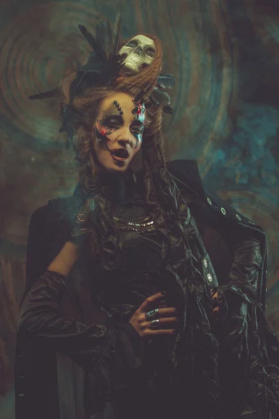 Jonge vrouw in donker kostuum. Heldere make-up en rook-Halloween thema. — Stockfoto