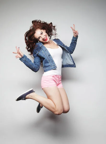 Estilo de vida y el concepto de la gente: sonriente mujer joven saltando en el aire — Foto de Stock