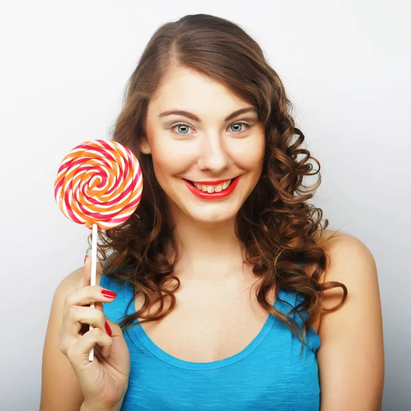 Funny curly woman holding big lollipop. — Stock Photo, Image