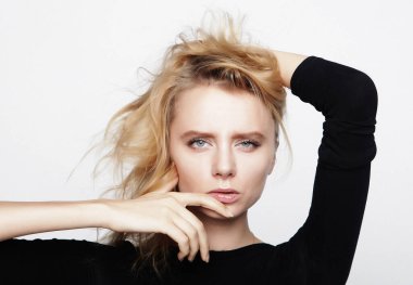 Siyah gömlekli, sarı saçlı genç bir kadının portresi.