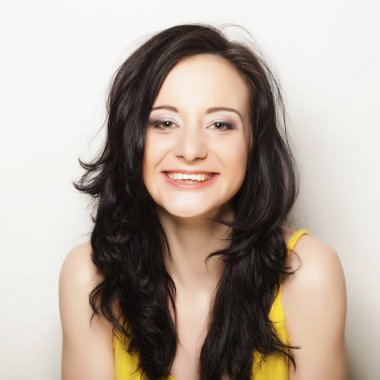 Beyaz arka planda gülümseyen güzel esmer kız.