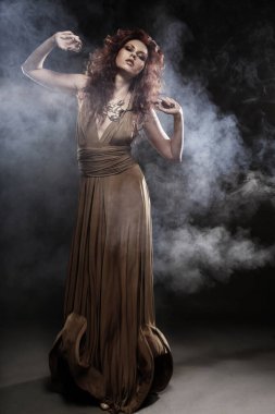 Bej renkli uzun elbiseli genç kadın.