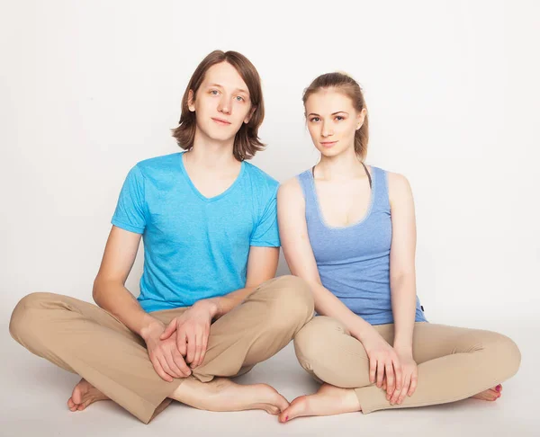 Estilo de vida, esporte e conceito de pessoas: Jovem casal em pose de ioga — Fotografia de Stock