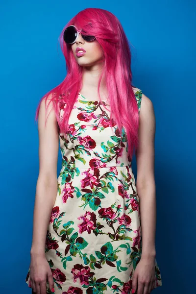 蓝色背景的粉色头发和大太阳镜的时装模特 — 图库照片