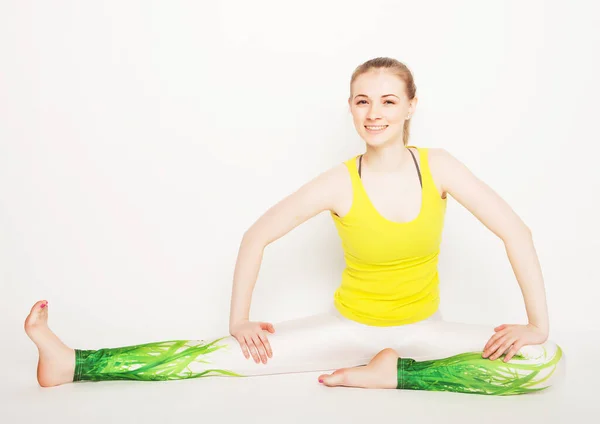 Livsstil, sport och människor koncept: ung kvinna i yoga pose sitter på en floo — Stockfoto