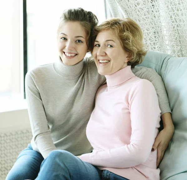 Hermosa mamá mayor y su hija adulta están abrazando, mirando a la cámara y sonriendo. —  Fotos de Stock