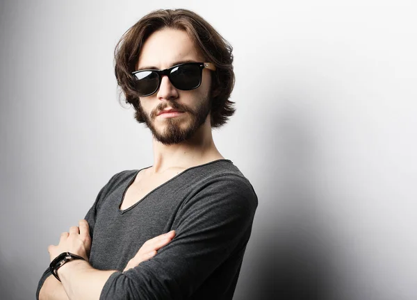 Fashion and people concept: portrait of a young man wearing sunglasses on light grey background — Stock Photo, Image