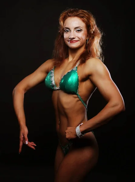 Blond bodybuilder kvinna i bikin på svart bakgrund — Stockfoto