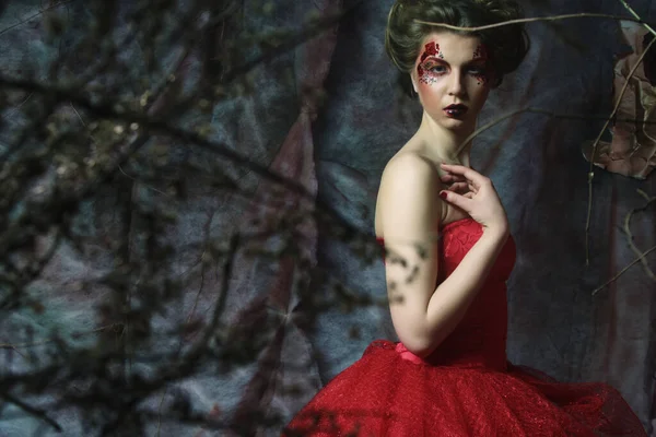 Mulher de vestido vermelho. Penteado fantástico e maquiagem . — Fotografia de Stock