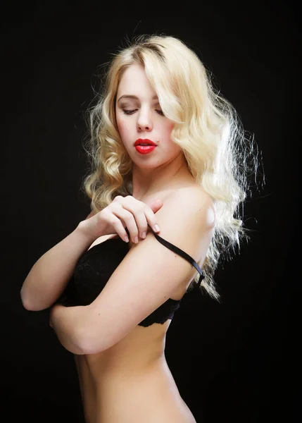 Blond vrouw met krullend haar in zwart lingerie — Stockfoto