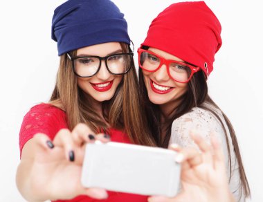 Hippi kıyafetli iki genç kız arkadaş selfie çekiyorlar.