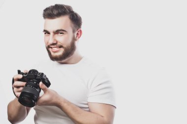 Genç sakallı fotoğrafçı dijital kamerayla fotoğraf çekiyor..