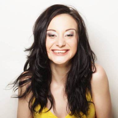 Beyaz arka planda gülümseyen güzel esmer kız.