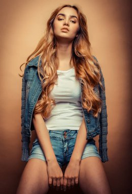 Stüdyoda sarı arka planda poz veren güzel elbiseli manken.