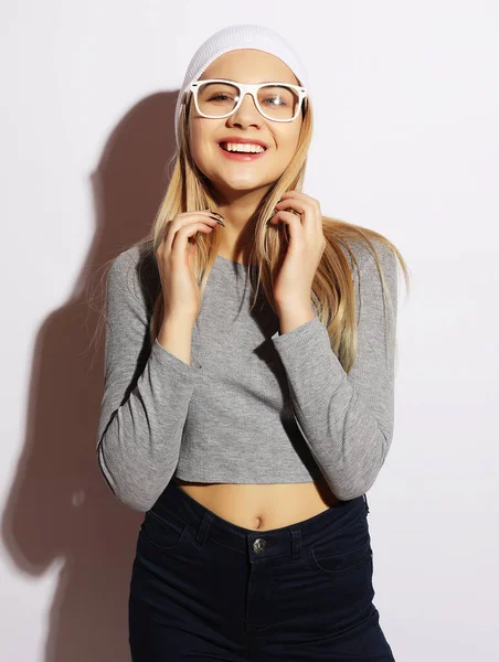 Coole Hipster-Studentin mit weißer Brille und Hut. Kaukasische Studentin blickt glücklich in die Kamera. — Stockfoto