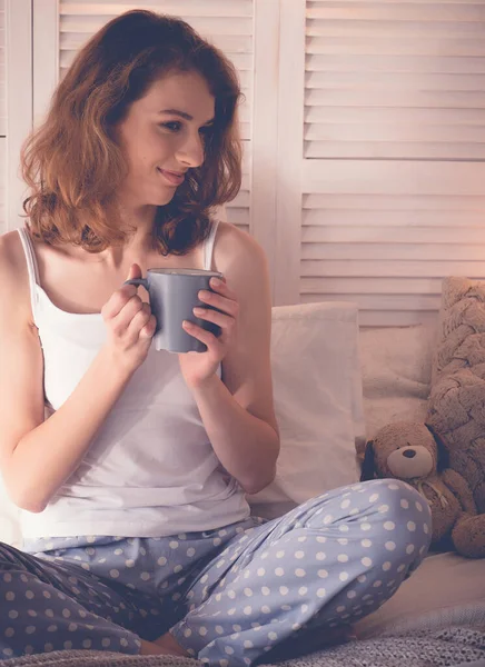 Mulher bonita bebendo café sentado na cama em casa — Fotografia de Stock