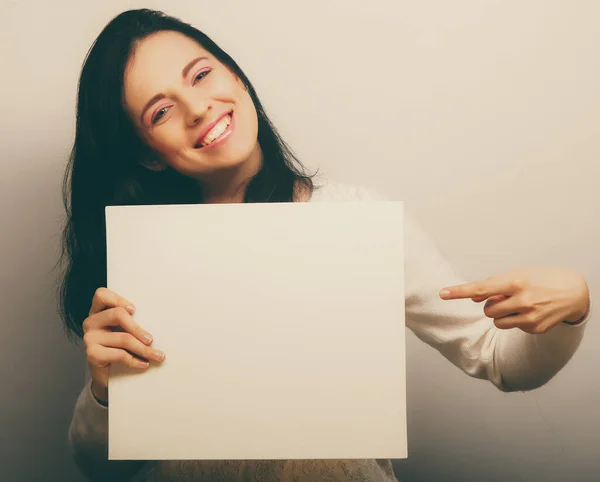 Souriant jeune femme de style décontracté montrant panneau vierge — Photo