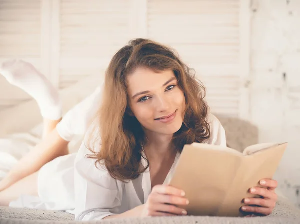 Hermosa mujer rubia leyendo libro en la cama. Concepto relajante — Foto de Stock