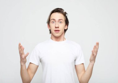 Yaşam tarzı, duygu ve insan konsepti: genç bir adamın portresi şaşırmış yüz ifadesi