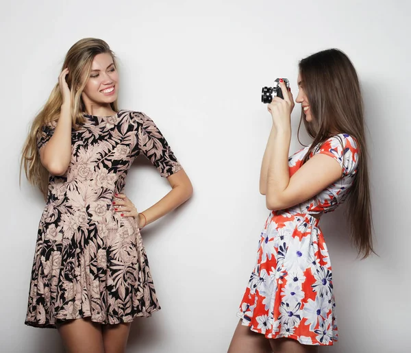 Belle giovani donne in abiti estivi sono fotografati su una macchina fotografica d'epoca, sfondo bianco — Foto Stock