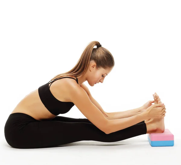 Young woman practicing yoga using yoga blocks — Stock Photo, Image