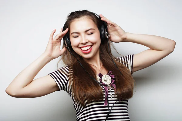 Jonge vrouw die naar muziek luistert. Gelukkige en koptelefoon. — Stockfoto