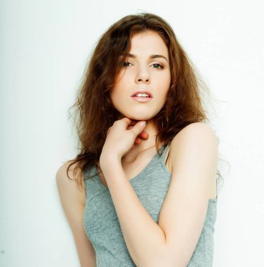 Genç, güzel kıvırcık kadın beyaz arka planda poz veriyor.