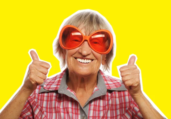 Старша жінка в великих сонцезахисних окулярах робить фанк-дію — стокове фото