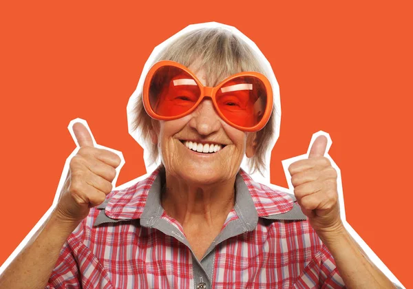 Ηλικιωμένη γυναίκα που φοράει μεγάλα γυαλιά ηλίου κάνει funky δράση — Φωτογραφία Αρχείου