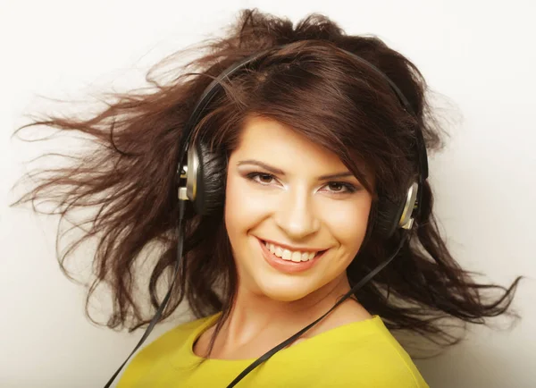 Mujer con auriculares escuchando música. Chica de la música bailando sobre fondo blanco . — Foto de Stock