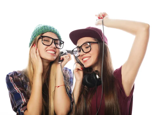Dos amigas jóvenes de pie juntas escuchando música y cantando —  Fotos de Stock
